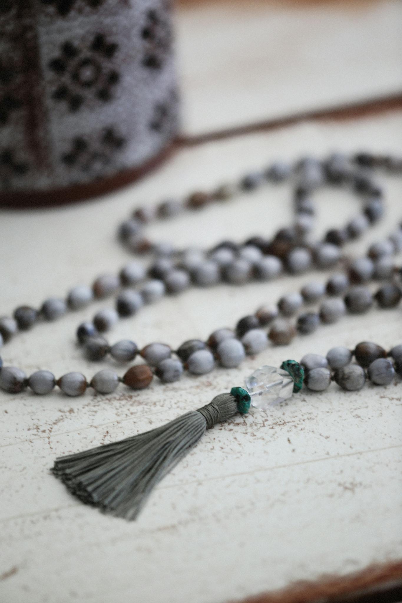 Close-up of prayer beads with a tassel on a rustic wooden table, evoking spirituality and tranquility.